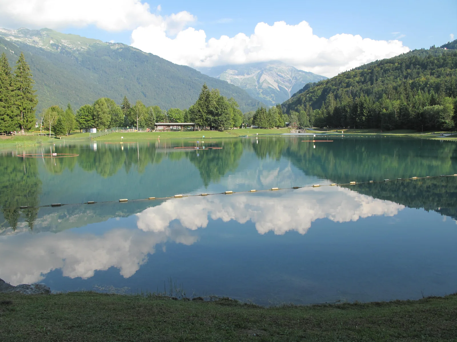 Les montagnes et les nuages se reflètent dans les Lacs aux Dames, à Samoëns.